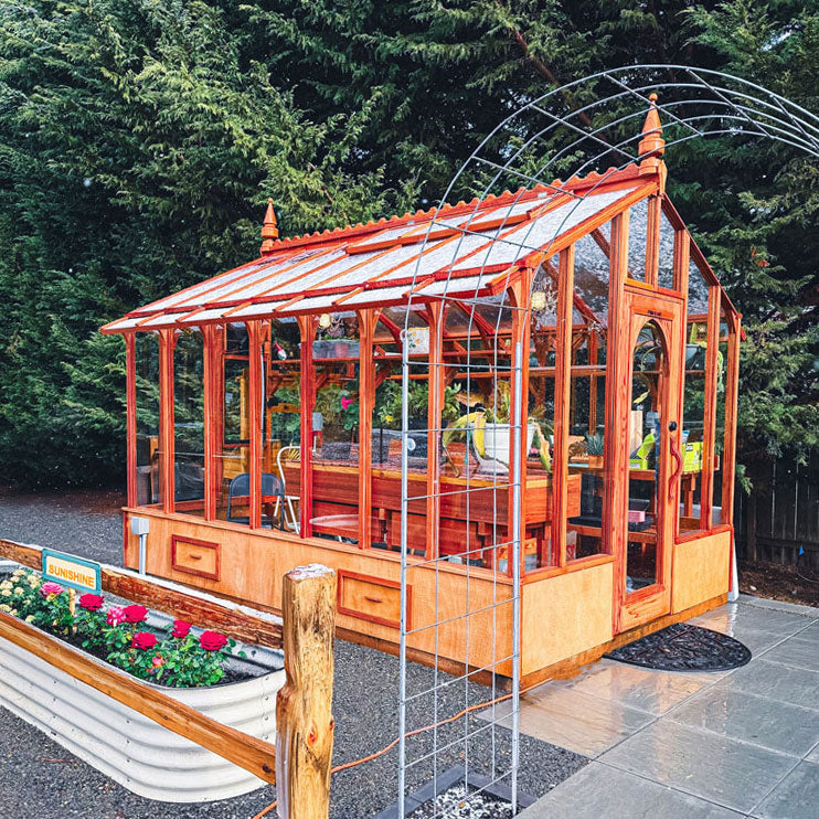 Wooden greenhouse with glass panels in a garden setting