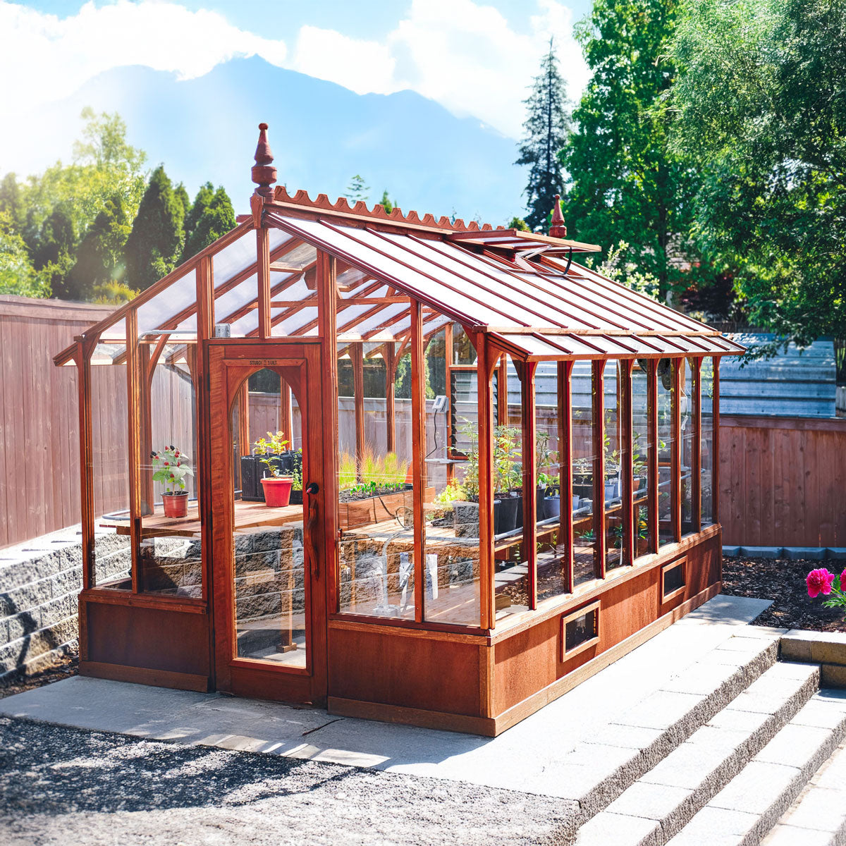 Wooden greenhouse with glass panels in a backyard setting