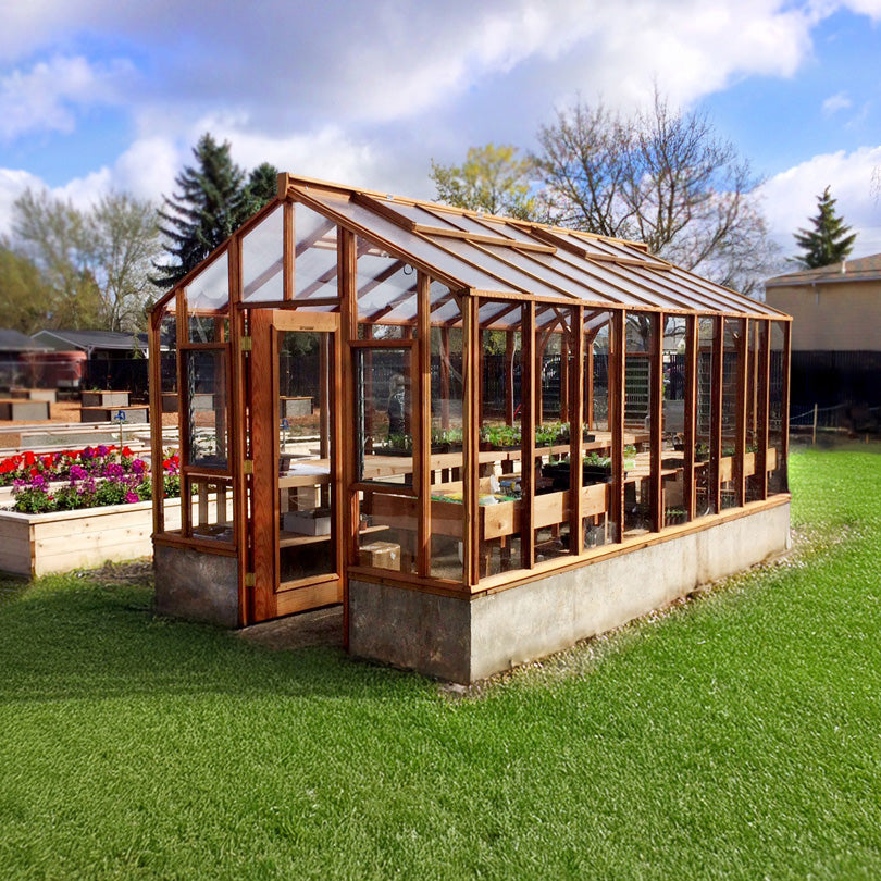 Wooden greenhouse with glass panels on a grassy area