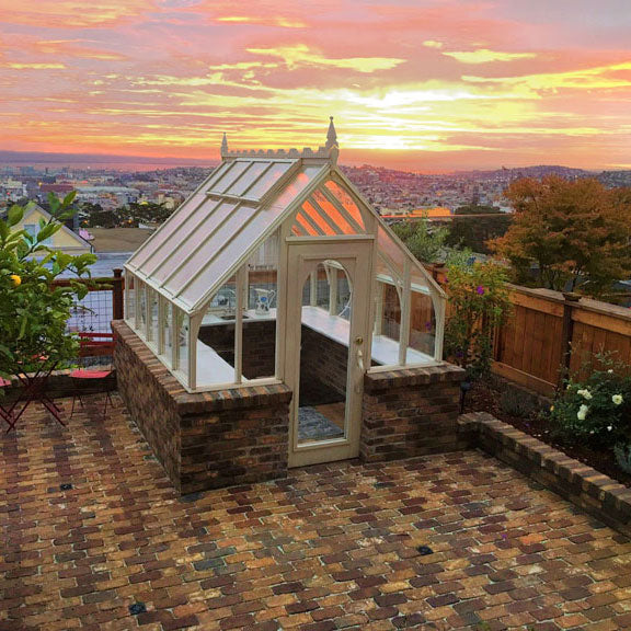 Greenhouse on a brick patio with a scenic sunset view