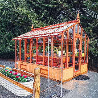 Wooden greenhouse with glass panels in a garden setting