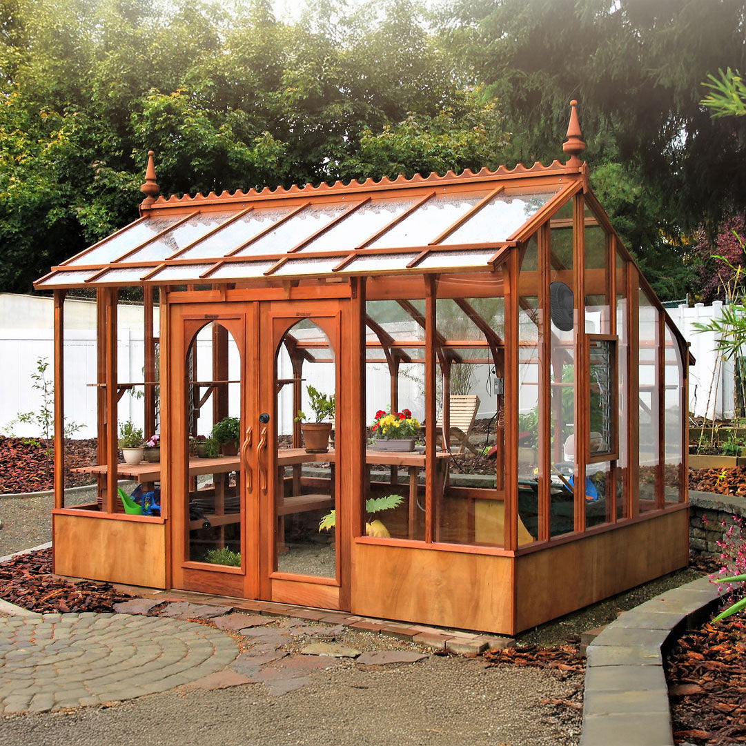 Wooden greenhouse with glass panels in a garden setting