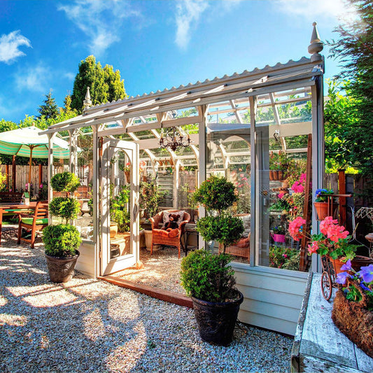 Greenhouse with plants and furniture in a garden setting